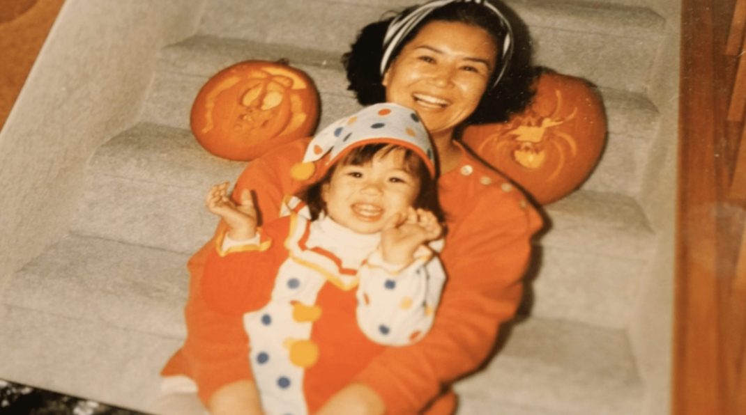 A baby picture shows a toddler dressed for Halloween in her mom's arms.