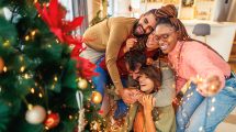 5 Friends having fun decorating Christmas tree