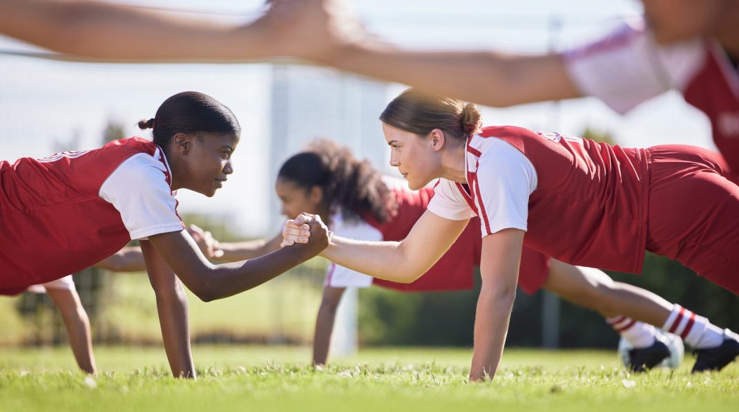 Women soccer, football or team sports holding hands in unity, support or motivation in routine work