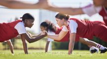 Women soccer, football or team sports holding hands in unity, support or motivation in routine work