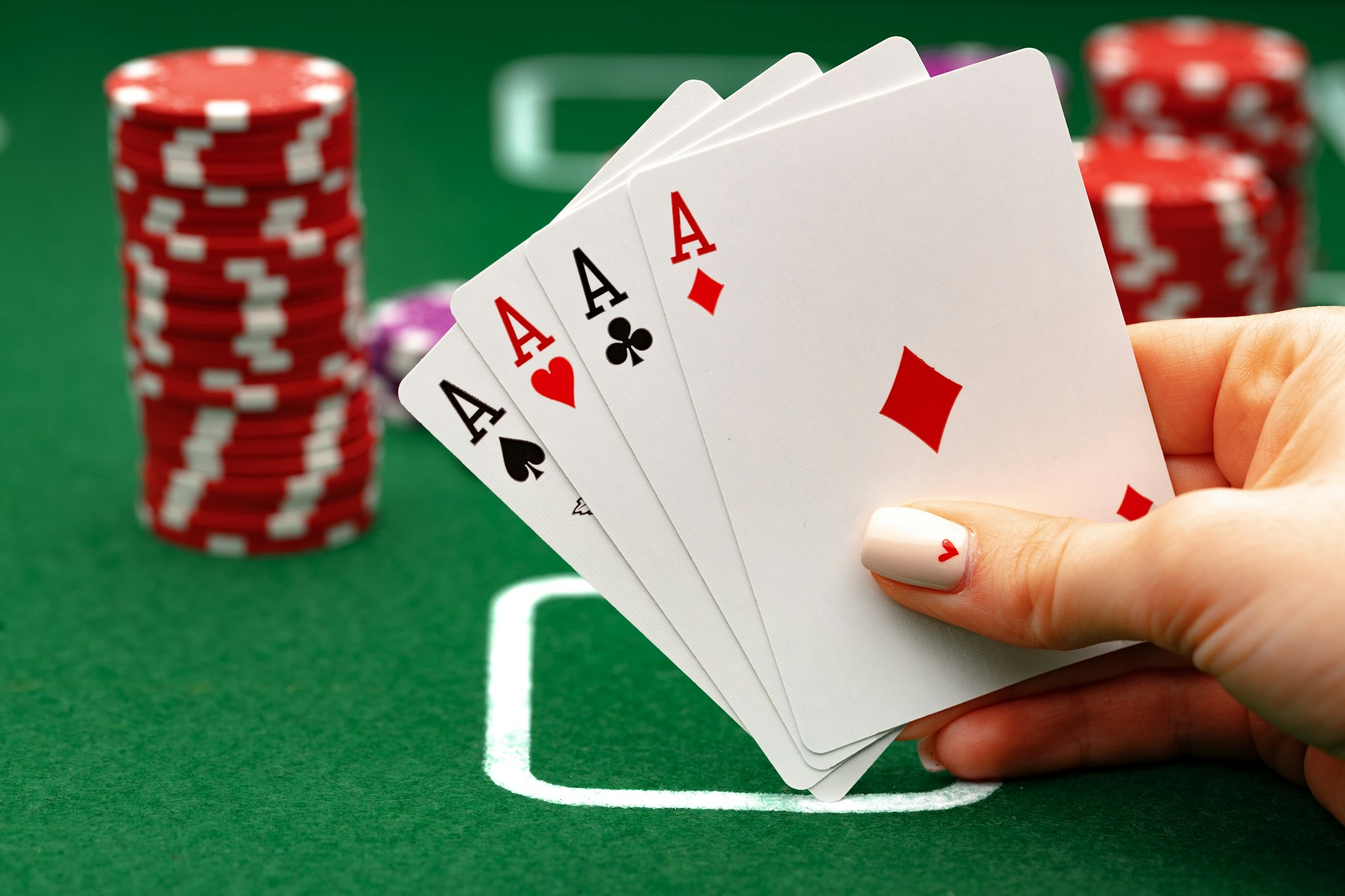 Female holding playing cards, playing poker at green table