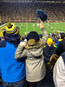 Fans cheering at a college football game in winter