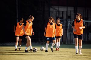 Female soccer players having sports training at the stadium.