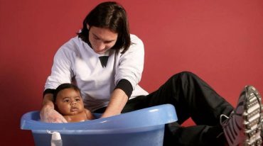 Lionel Messi bathing a young Lamine Yamal (Photo by Joan Monfort/UNICEF)