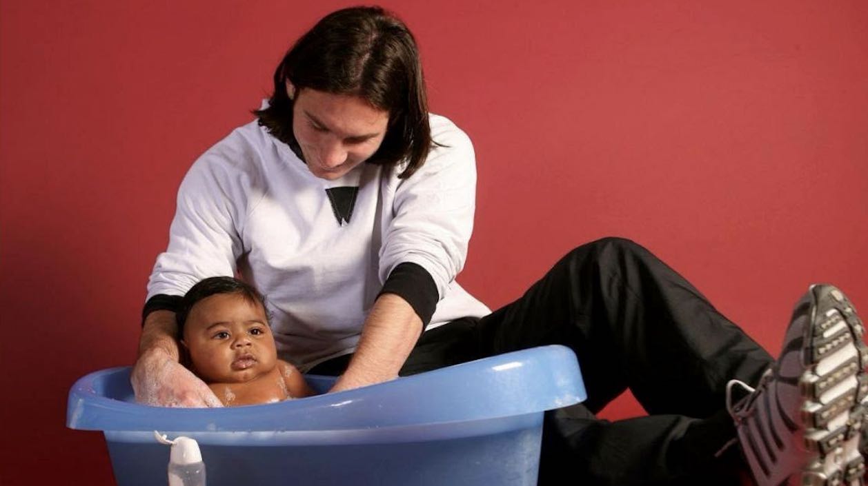 Lionel Messi bathing a young Lamine Yamal (Photo by Joan Monfort/UNICEF)